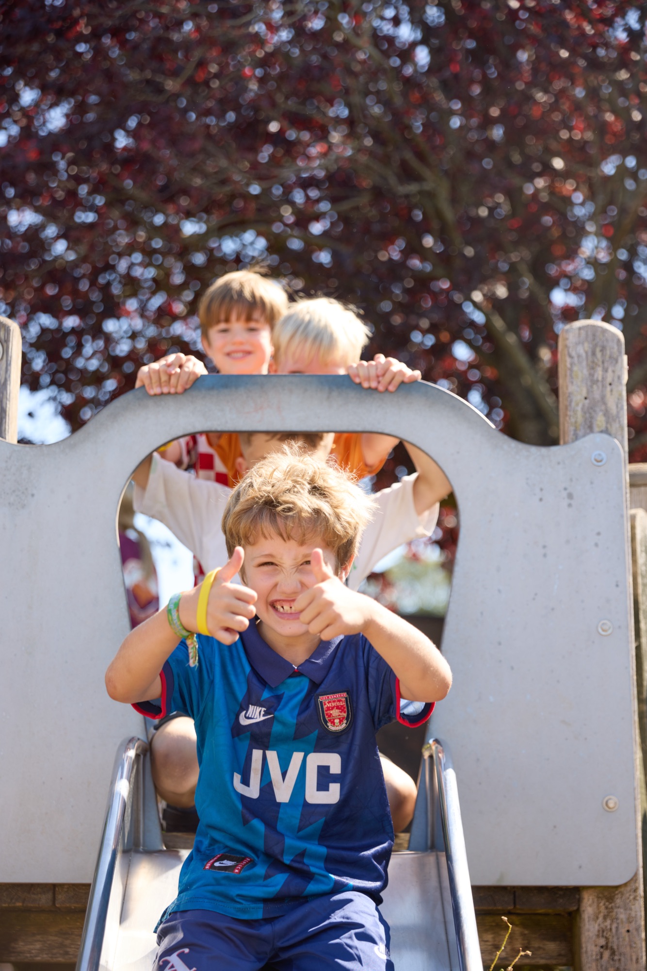 Child giving thumbs up on a slide