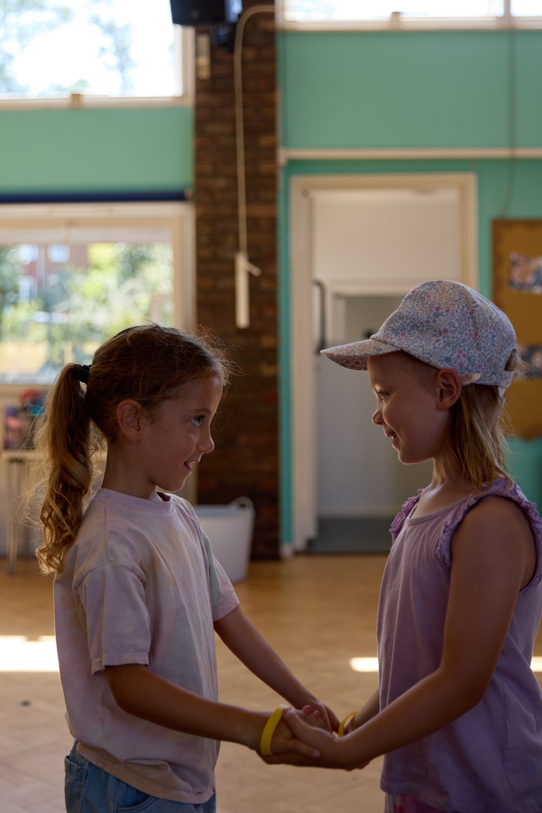 Two girls holding hands and chatting