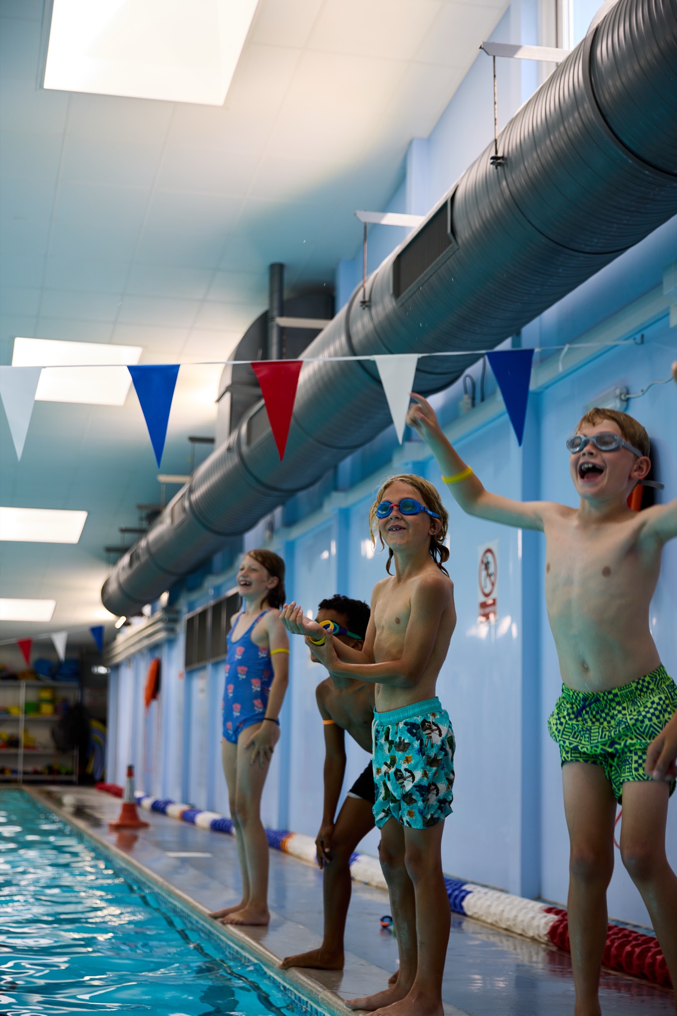 Children lined up poolside ready to swim